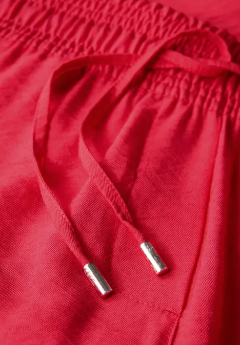 Roter Stoff mit Kordelzug und elastischem Bund.